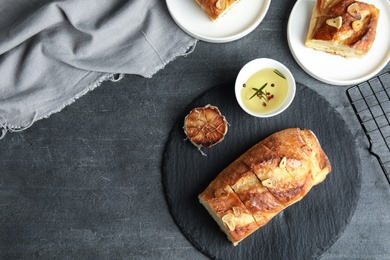 Photo of Flat lay composition with tasty homemade garlic bread and space for text on table