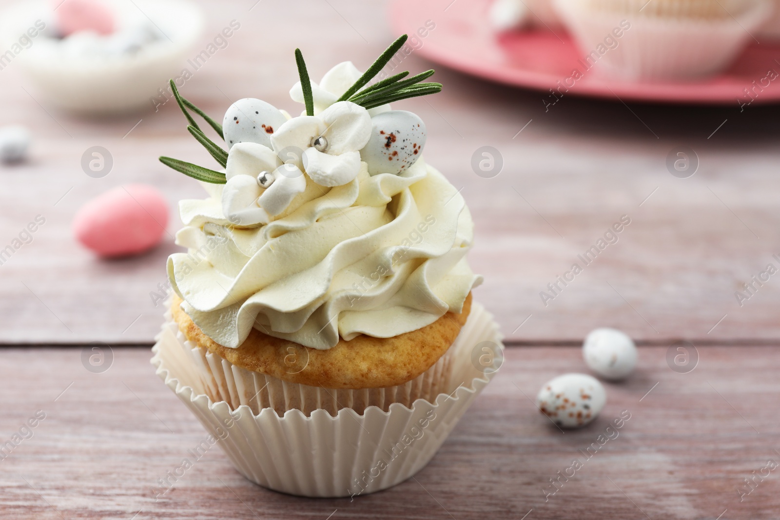 Photo of Tasty Easter cupcake with vanilla cream on wooden table