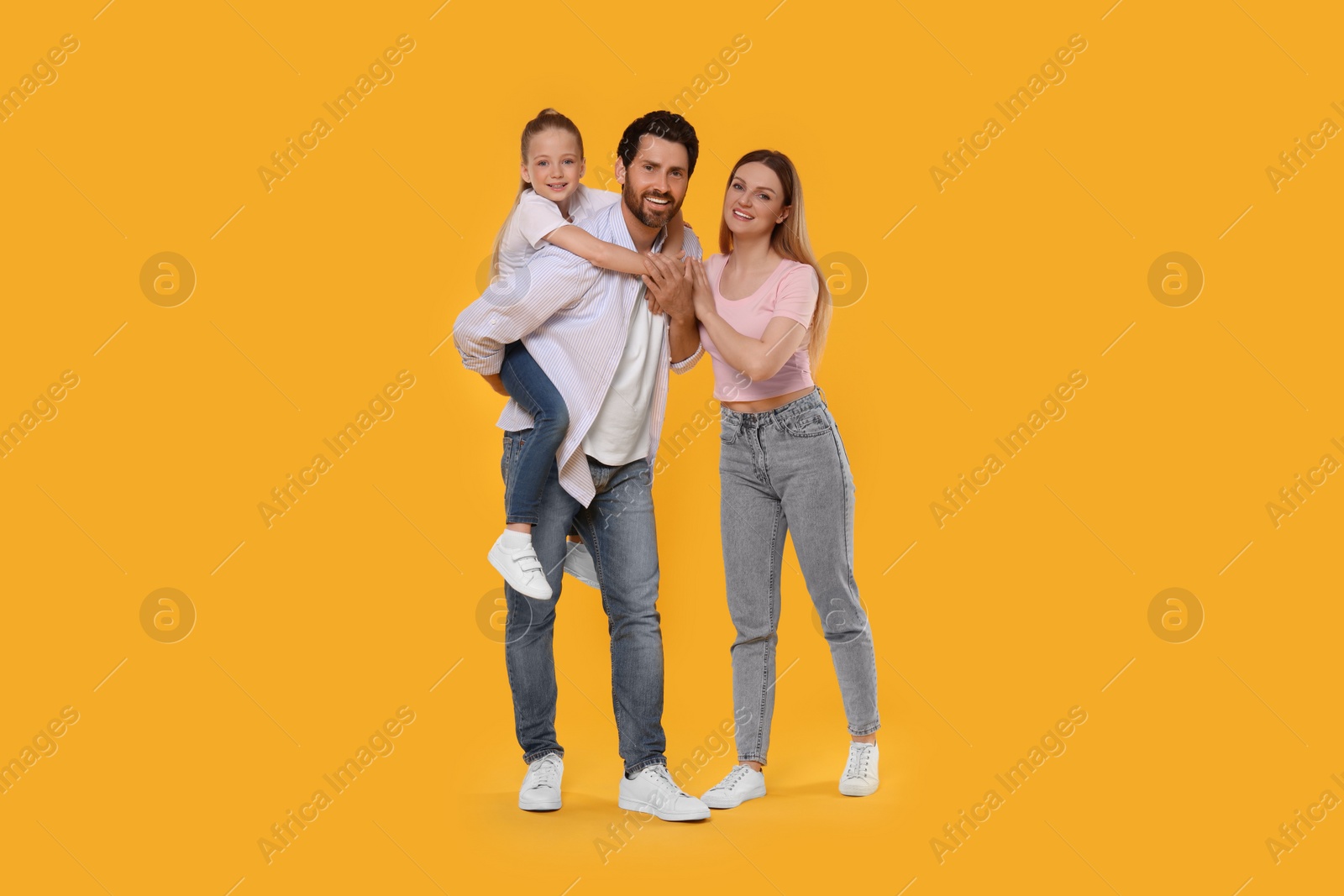 Photo of Portrait of happy family on orange background