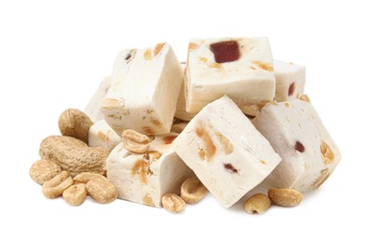 Photo of Pieces of delicious nougat and nuts on white background