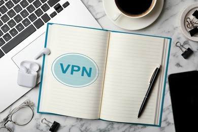 Notebook with acronym VPN on white marble table, flat lay. Secure network connection
