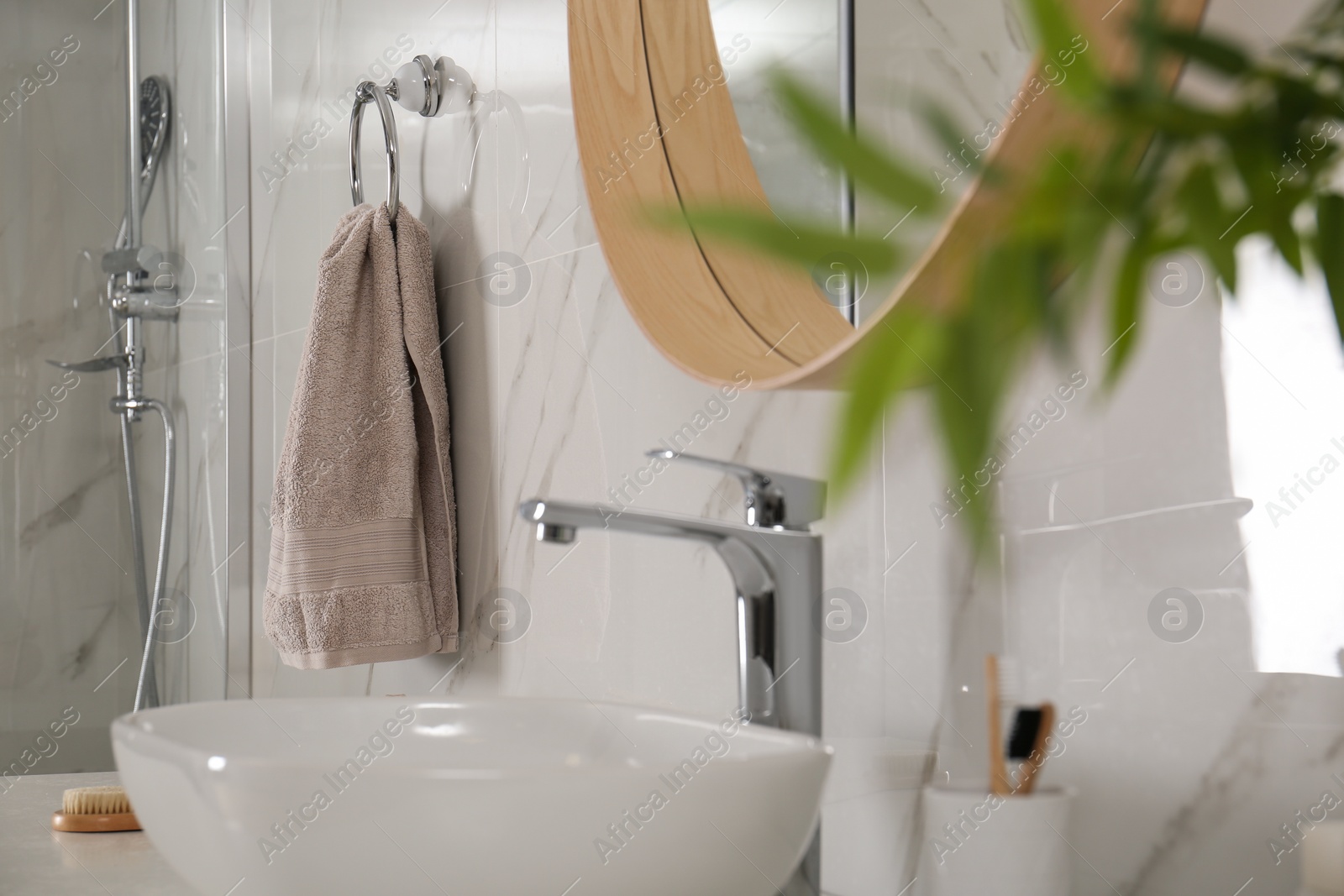 Photo of Bathroom interior with mirror, countertop and soft towel on wall