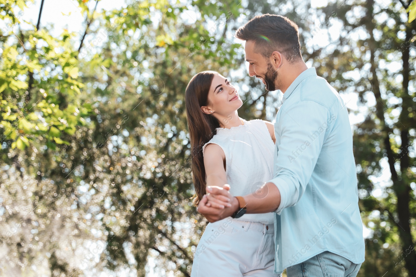 Photo of Lovely young couple dancing together in park on sunny day