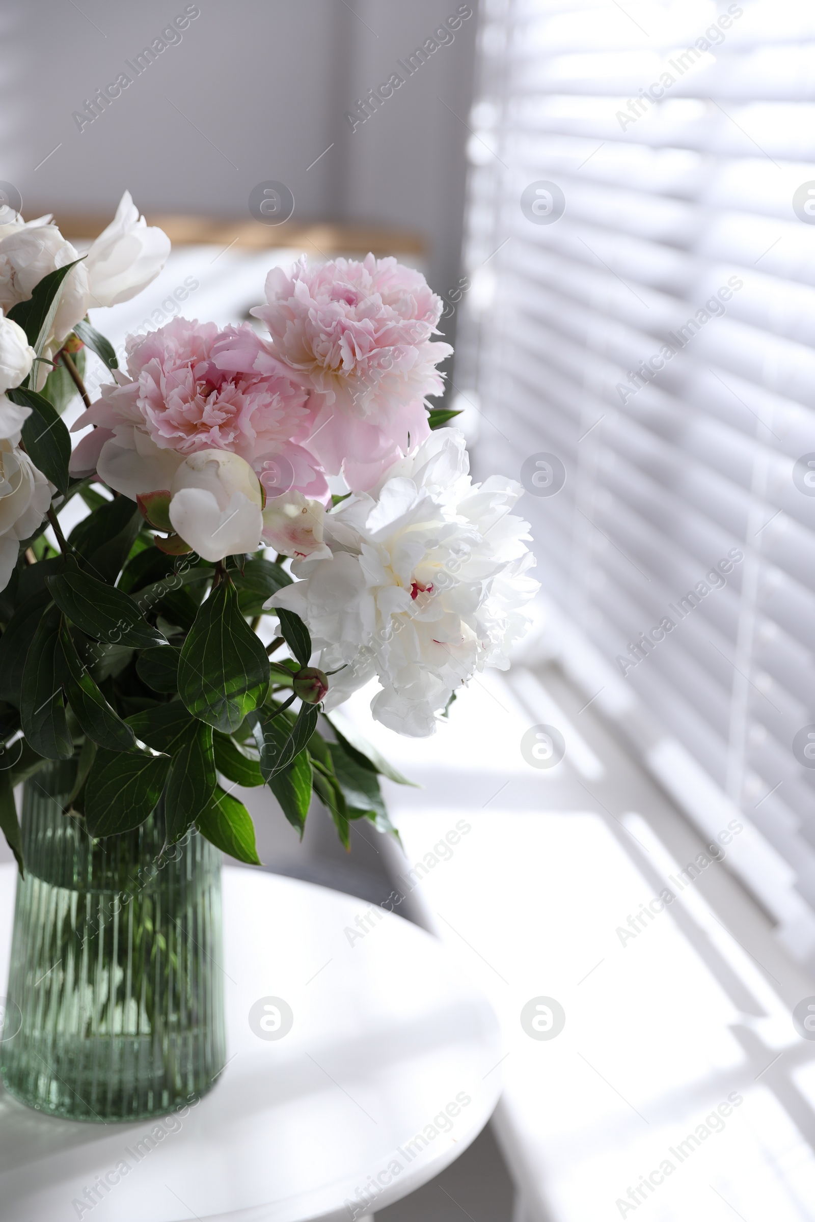 Photo of Bouquet of beautiful peony flowers on table indoors