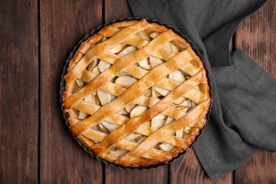 Delicious traditional apple pie on wooden table, top view