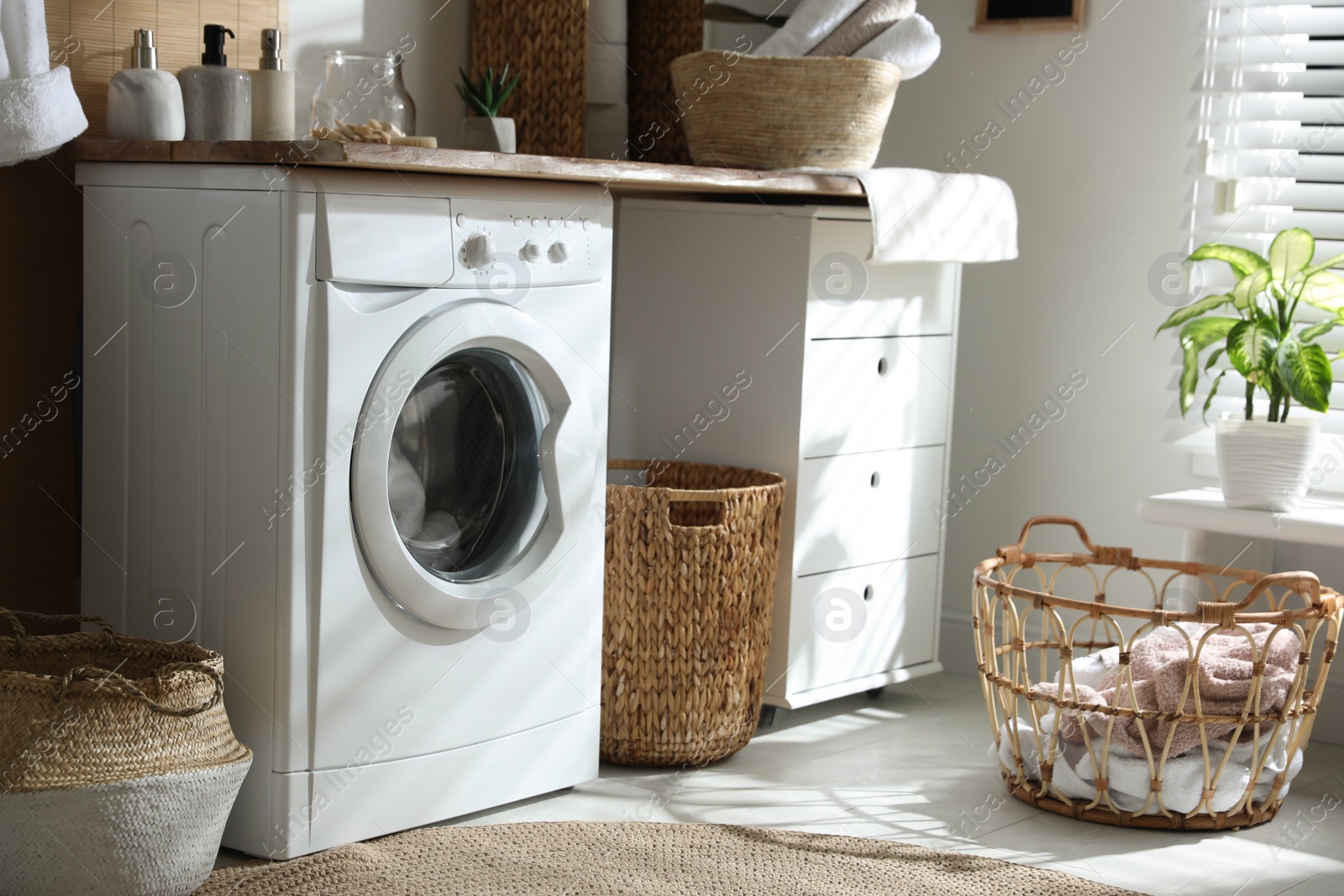 Photo of Stylish bathroom interior with modern washing machine