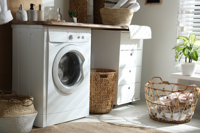 Stylish bathroom interior with modern washing machine