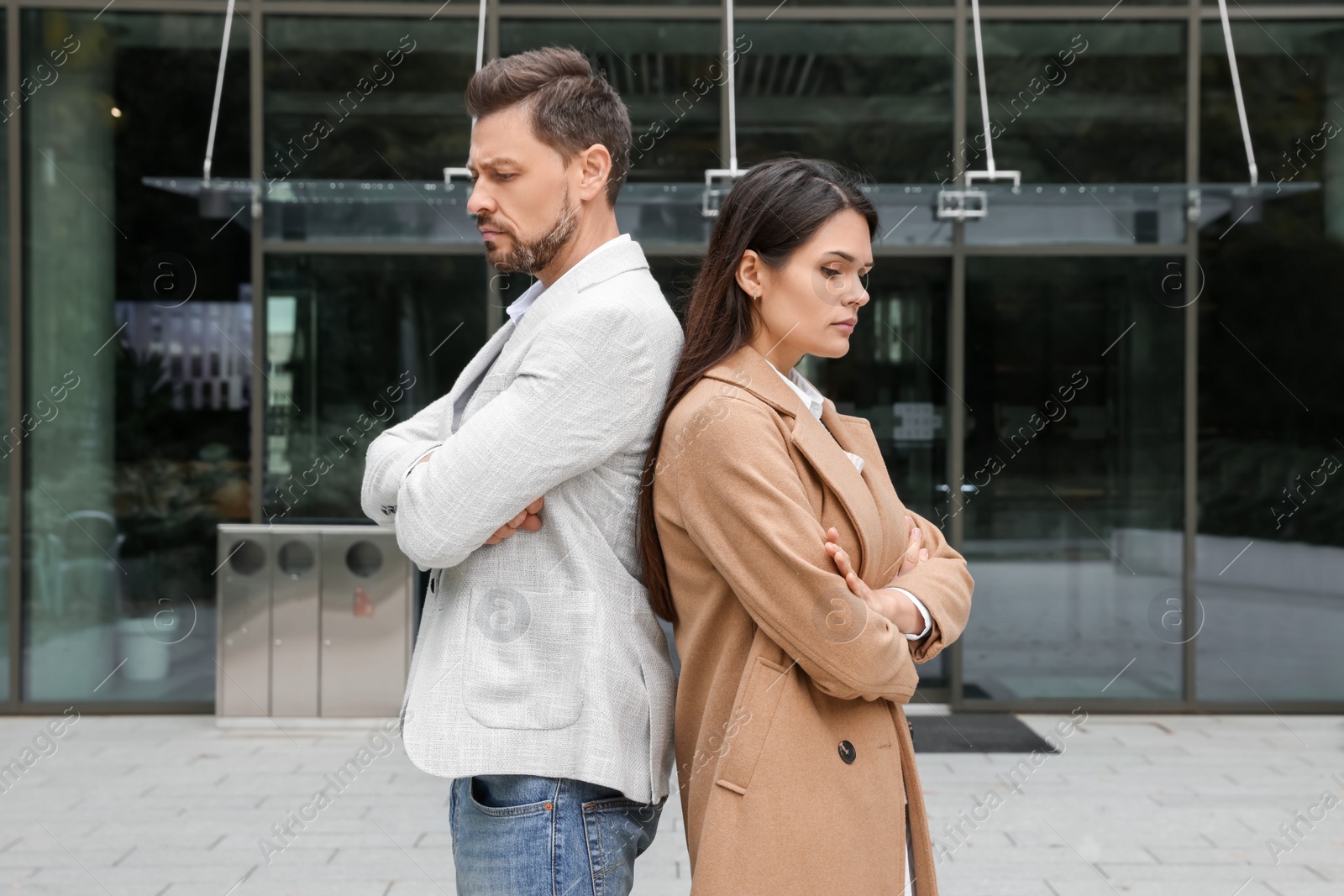 Photo of Upset arguing couple near building outdoors. Relationship problems