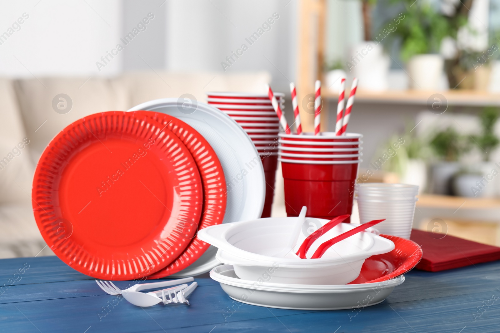 Photo of Disposable tableware on blue wooden table indoors