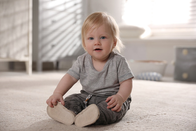 Photo of Adorable little baby on floor at home