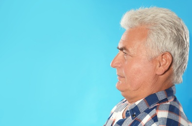 Photo of Mature man with double chin on blue background. Space for text