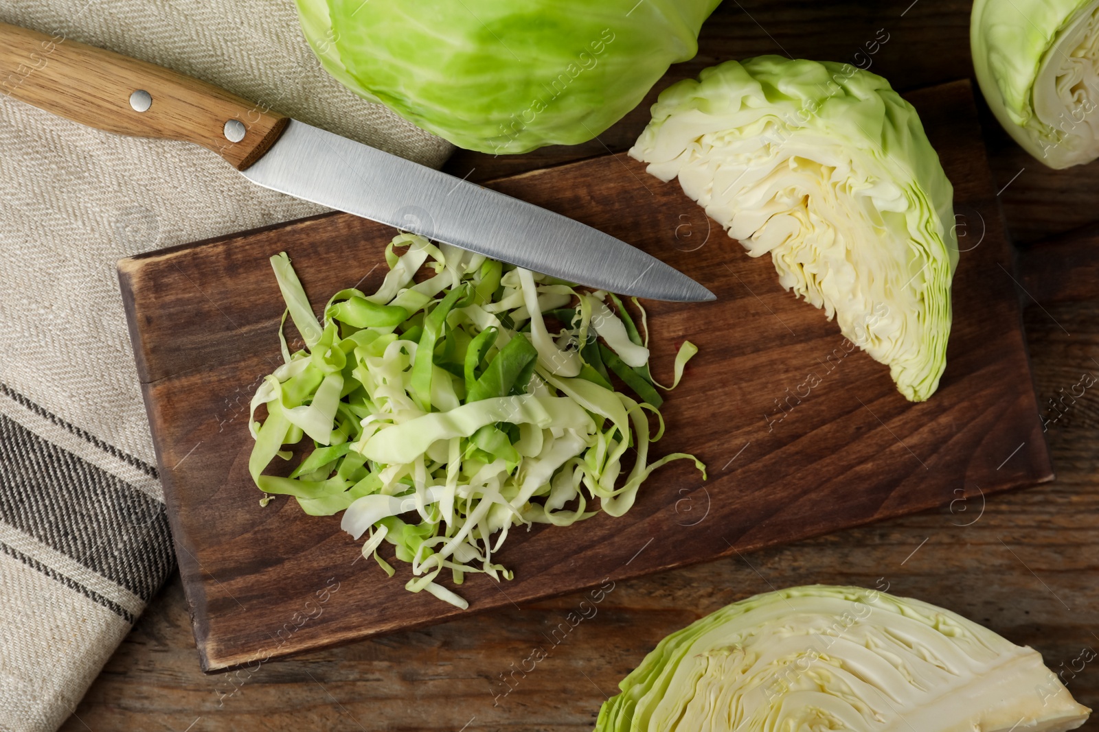 Photo of Chopped ripe cabbage on wooden table, flat lay