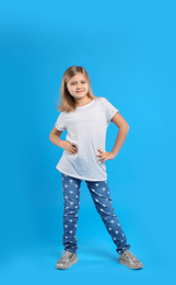 Cute little girl on light blue background