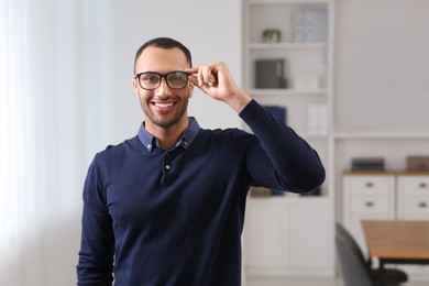 Photo of Smiling young businessman with eyeglasses in modern office