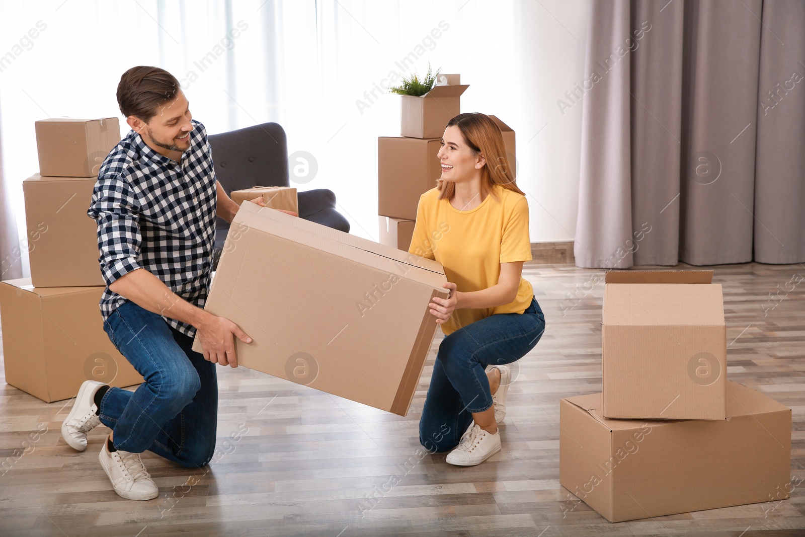 Photo of Couple with moving box in their new house