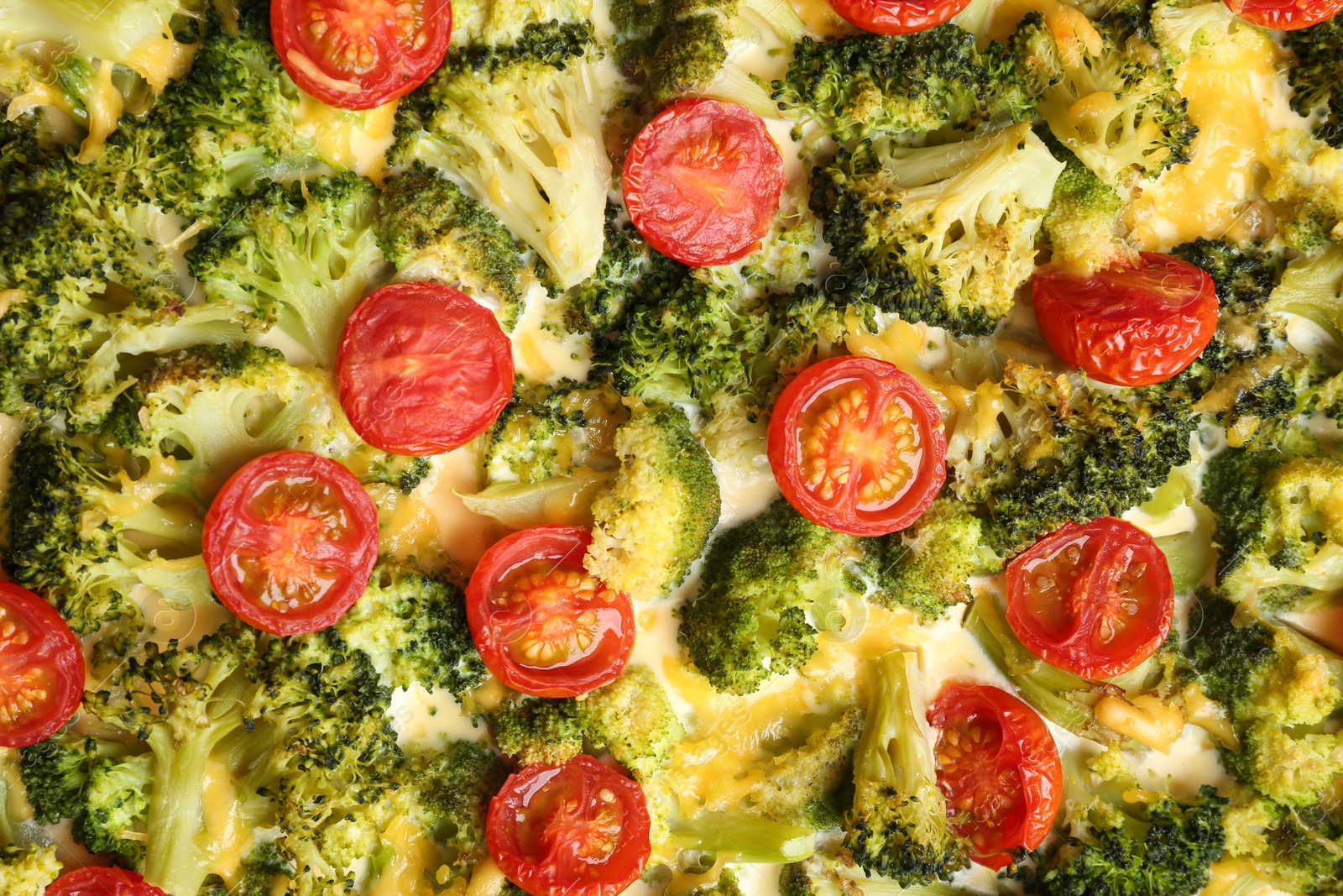 Photo of Tasty broccoli casserole with cherry tomatoes as background, closeup