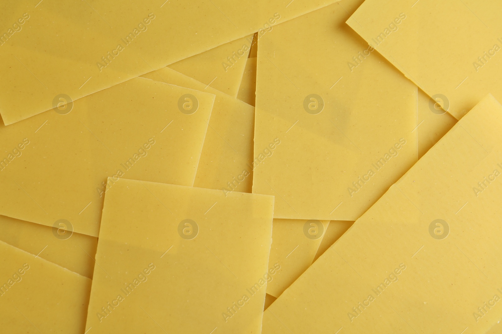 Photo of Pile of dry lasagna sheets as background, closeup