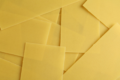 Photo of Pile of dry lasagna sheets as background, closeup