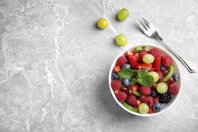 Photo of Fresh fruit salad on grey marble table, flat lay. Space for text