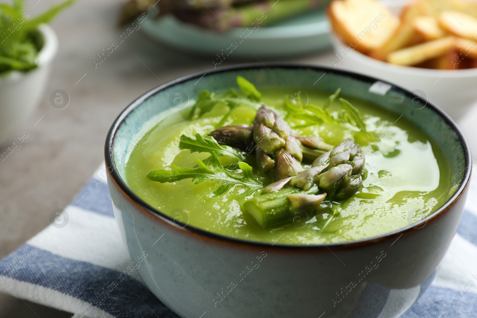 Photo of Delicious asparagus soup served on table, closeup