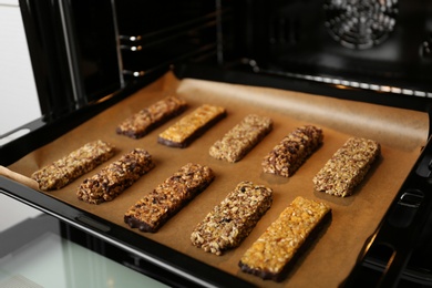 Photo of Delicious healthy granola bars on baking sheet in oven