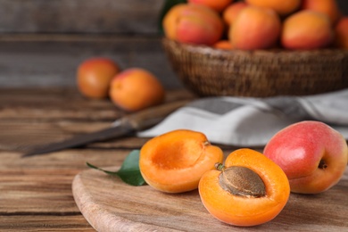 Photo of Delicious fresh ripe apricots on wooden table, closeup. Space for text