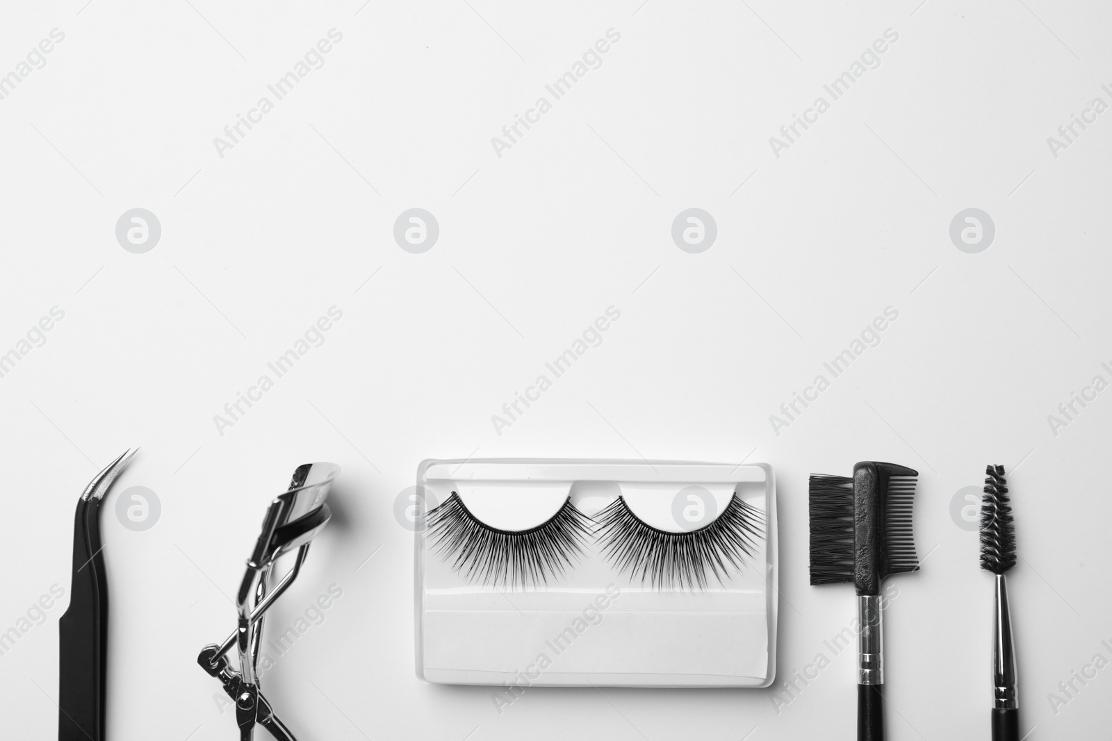 Photo of Flat lay composition of professional makeup tools and false eyelashes on white background