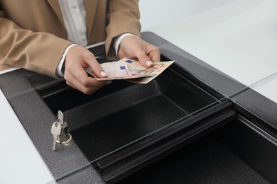 Cashier with money at bank, closeup. Currency exchange