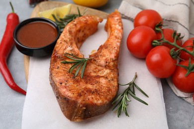 Photo of Fresh marinade and cooked fish on grey table, closeup