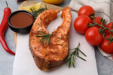 Fresh marinade and cooked fish on grey table, closeup