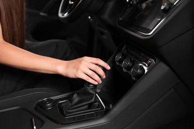 Young woman testing new car in salon