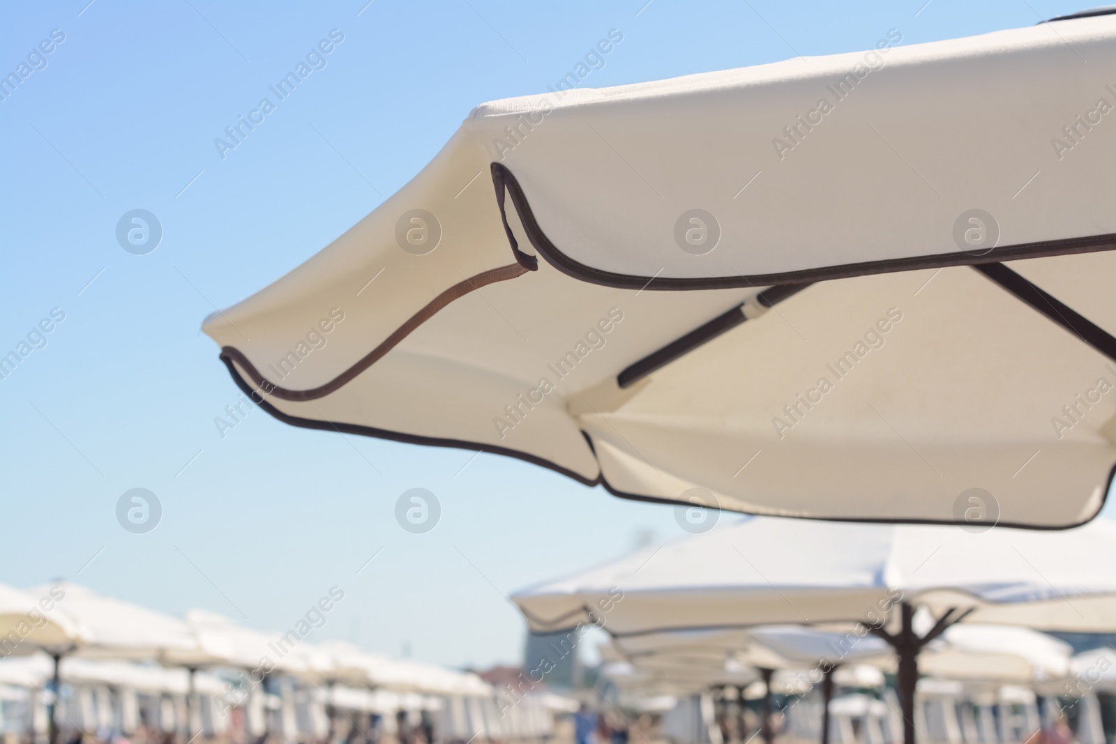 Photo of Beautiful white beach umbrella at resort, closeup