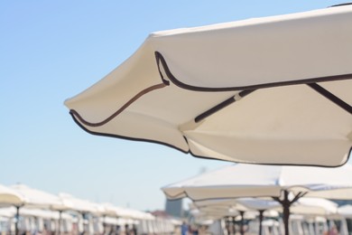 Photo of Beautiful white beach umbrella at resort, closeup