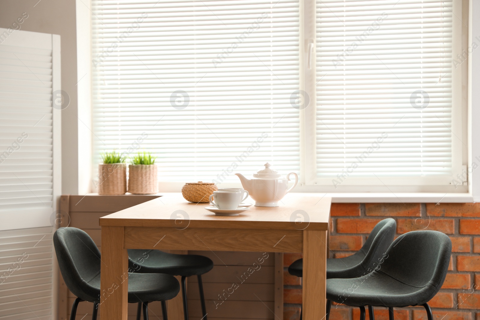 Photo of Stylish dining room interior with modern table set and window blinds