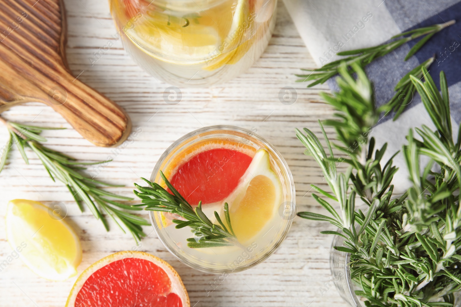 Photo of Flat lay composition with grapefruit and rosemary cocktail on light table