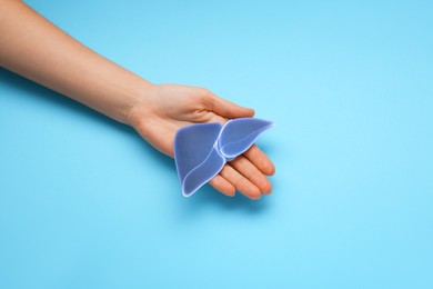 Photo of Woman holding paper liver on light blue background, closeup and space for text. Hepatitis treatment