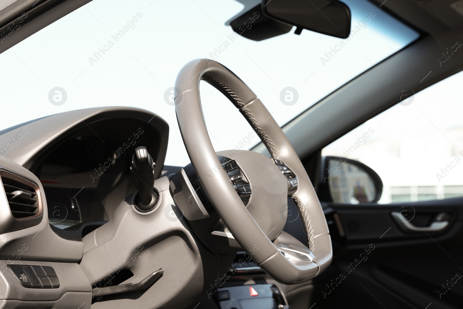 Photo of Black steering wheel and dashboard in modern car