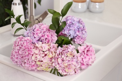 Photo of Bouquet with beautiful hydrangea flowers bouquet in sink, closeup