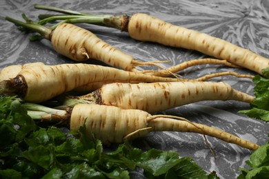 Delicious fresh ripe parsnips on grey table, closeup