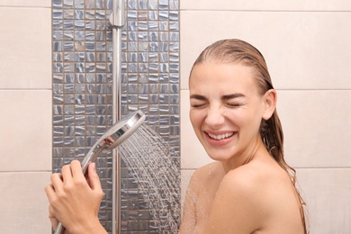 Beautiful young woman taking shower at home