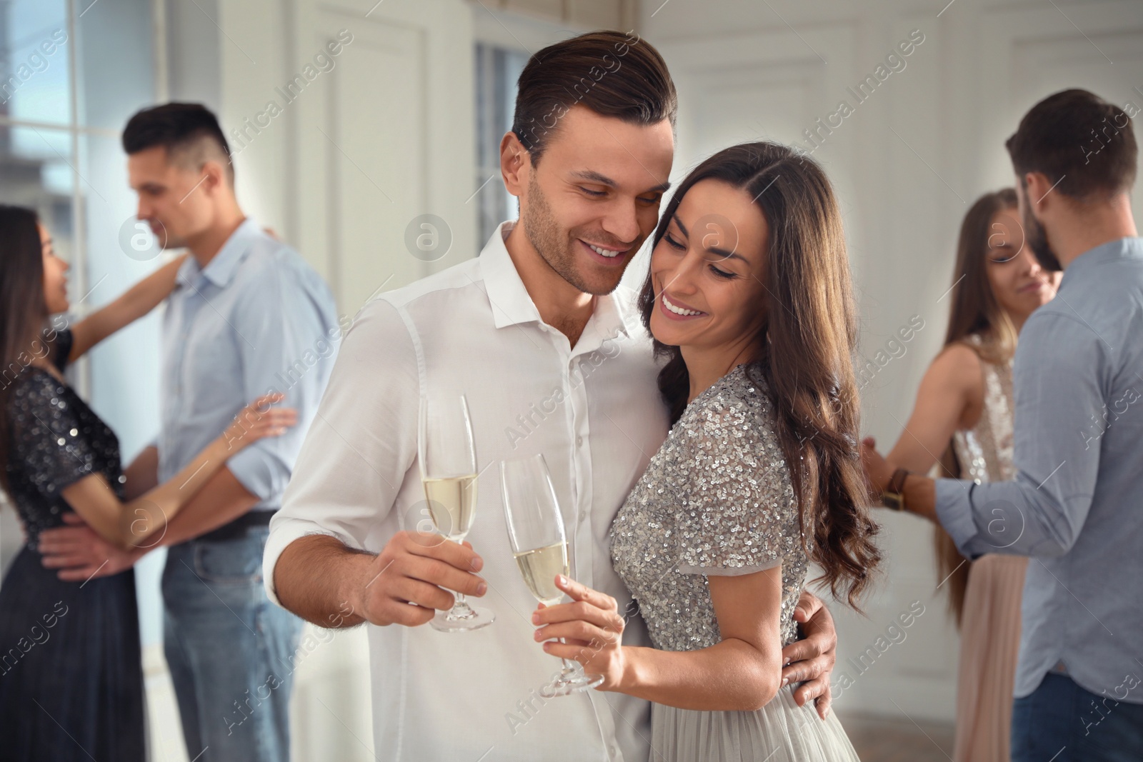 Photo of Lovely young couple with glasses of champagne at dancing party