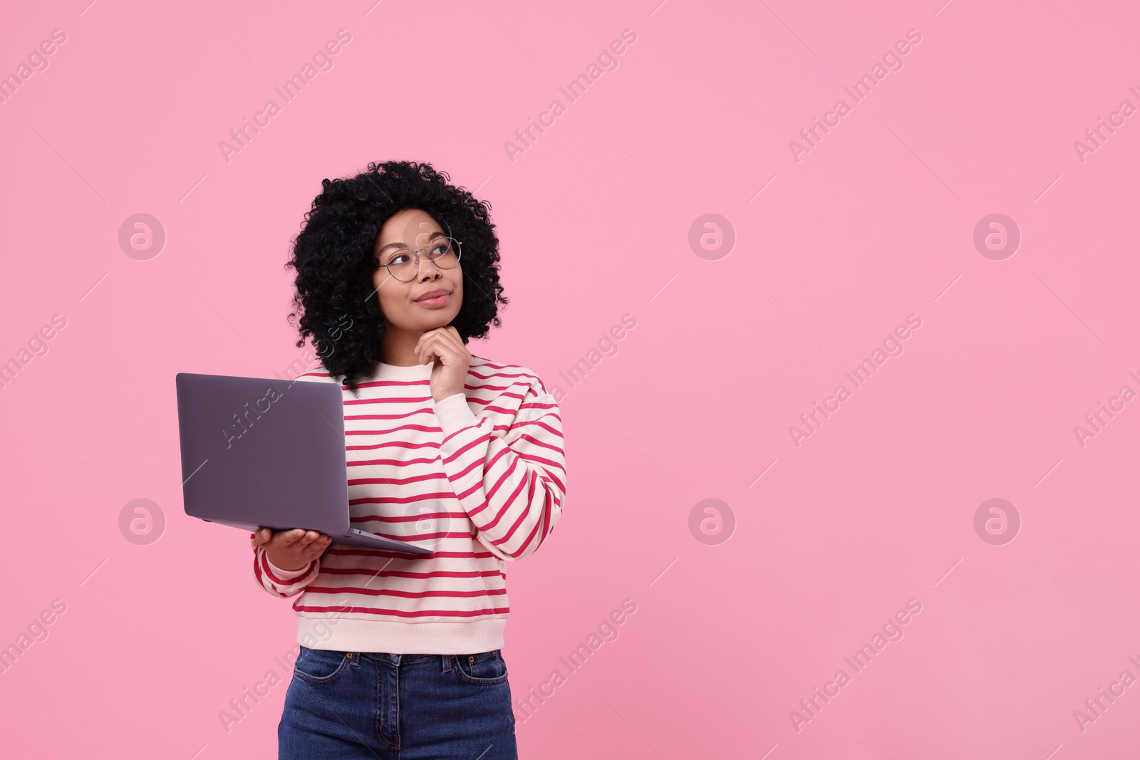 Photo of Beautiful young woman with laptop on pink background. Space for text