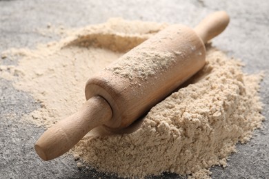 Photo of Rolling pin and flour on table, closeup