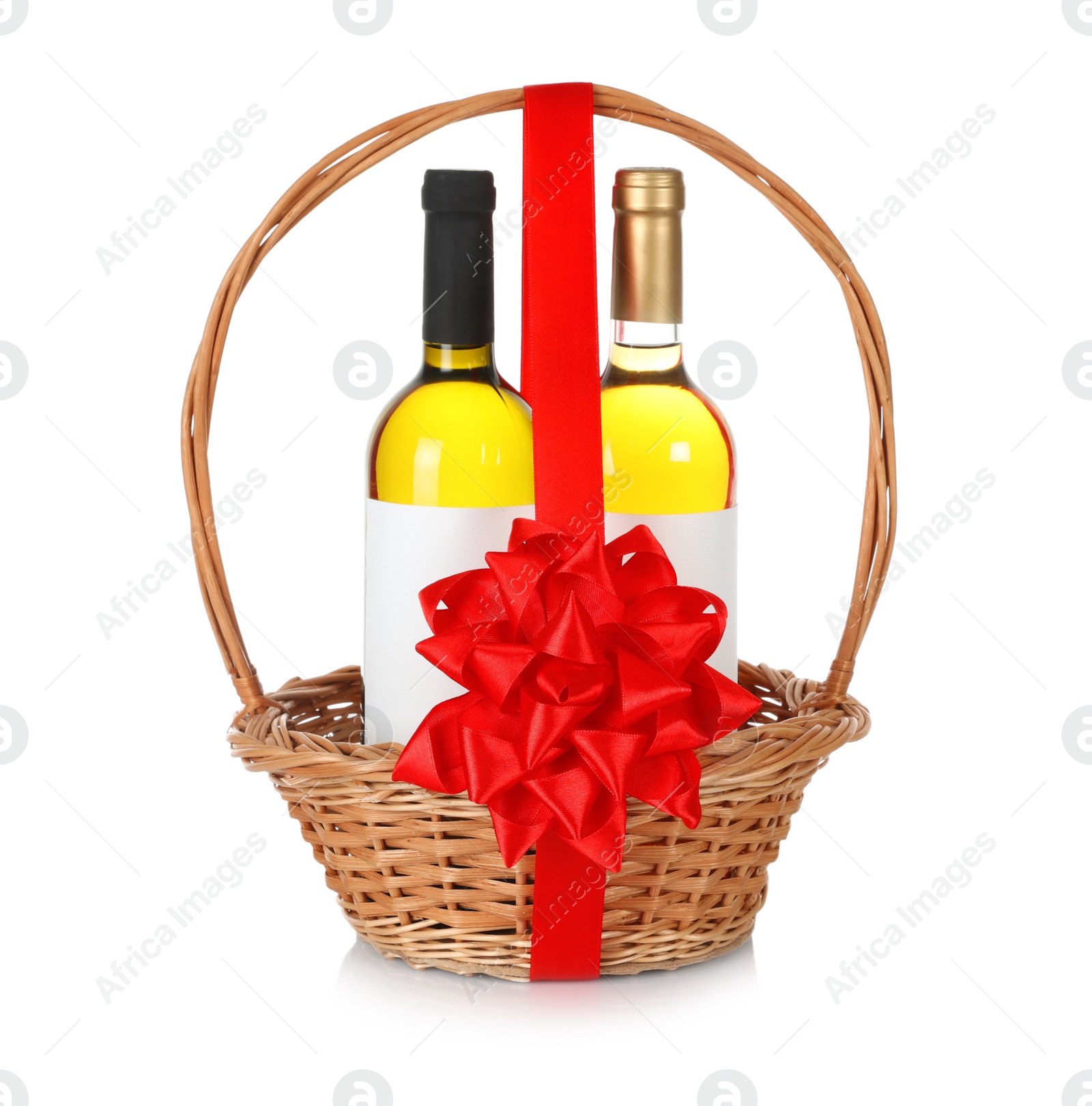 Photo of Bottles of wine in wicker basket with red bow isolated on white