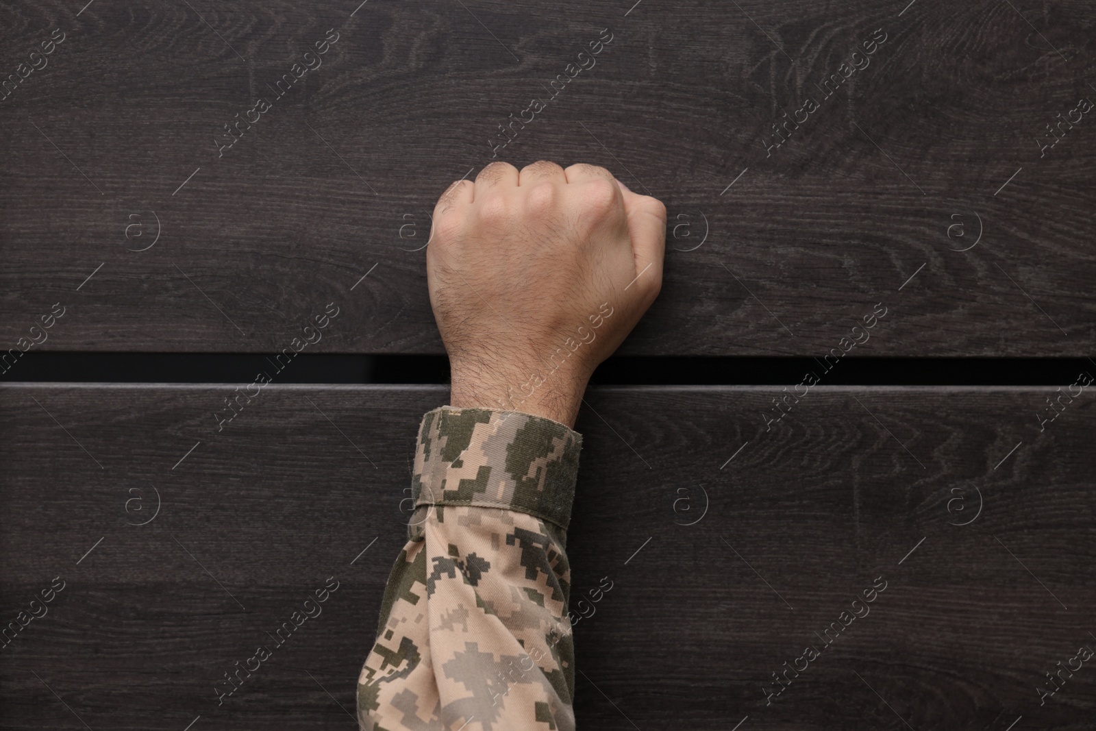 Photo of Military commissariat representative knocking on wooden door, closeup