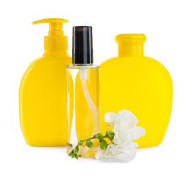 Photo of Baby oil, toiletries and flowers on white background