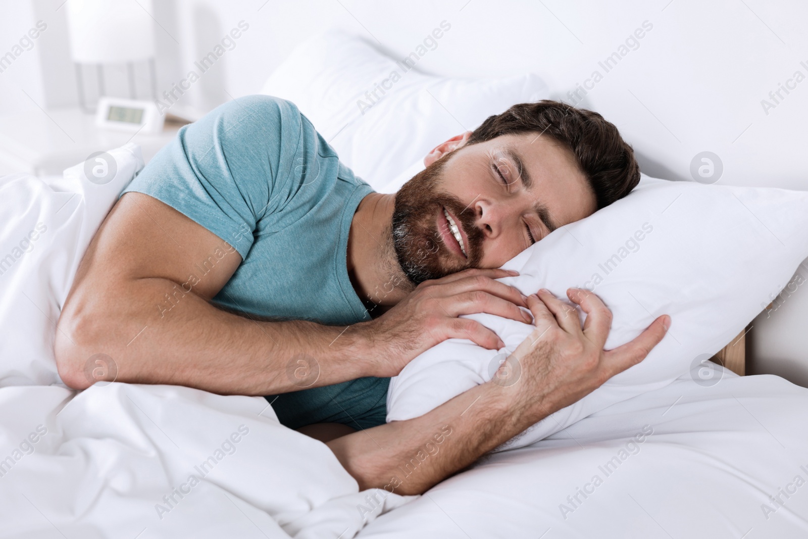 Photo of Man sleeping on comfortable pillows in bed at home