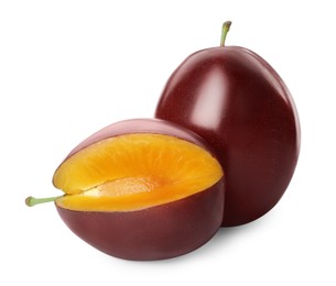 Whole and cut ripe plums on white background