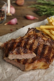 Photo of Tasty grilled beef steak on wooden table
