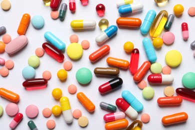 Lots of different colorful pills on white background, top view